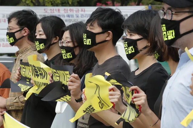 Environmental activists wearing face masks to help protect against the spread of the coronavirus stage a rally marking the Global Day of Climate Action near the government complex in Seoul, South Korea, Friday, September 25, 2020. The signs read: “We want to live”. (Photo by Ahn Young-joon/AP Photo)