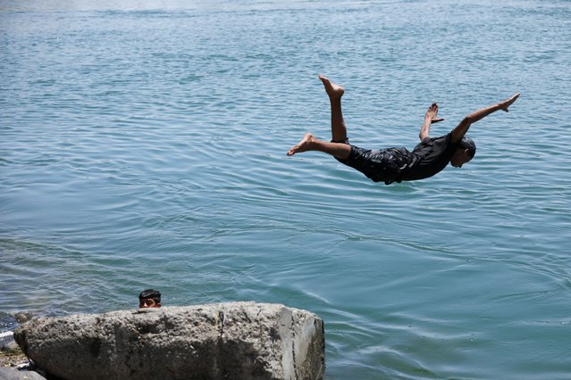 A man jump to the Euphrates River during a hot day in Raqqa, Syria on June 25, 2025. (Photo by Orhan Qereman/Reuters)