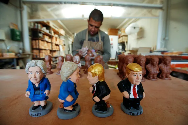 Traditional nativity “Caganer” figurines depicting U.S. Democratic presidential nominee Hillary Clinton and U.S. Republican presidential nominee Donald Trump are seen at a factory in Torroella de Montgri, northern Spain, September 26, 2016. The figurines depicted in the act of defecation are a tradition mostly in Spain's Catalonia region and are used in nativity scenes depicting the city of Bethlehem. (Photo by Albert Gea/Reuters)