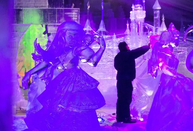 A sculptor carves an ice sculpture at the Disney Dreams Ice Festival in Antwerp November 27, 2014. (Photo by Yves Herman/Reuters)