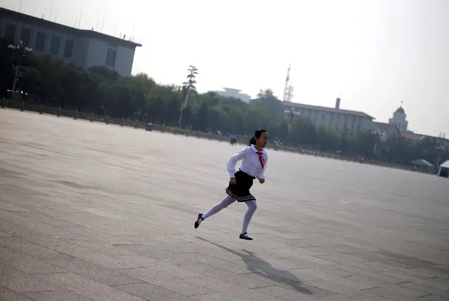 A student runs to attend a tribute ceremony in front of the Monument to the People's Heroes at Tiananmen Square, ahead of National Day marking the 67th anniversary of the founding of the People's Republic of China in Beijing, China, September 30, 2016. (Photo by Jason Lee/Reuters)