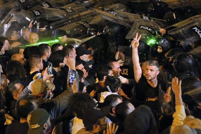 Police block protestors gathered outside the parliament building in Tbilisi, Georgia, on Tuesday, April 16, 2024, protesting against “the Russian law” similar to a law that Russia uses to stigmatize independent news media and organizations seen as being at odds with the Kremlin. (Photo by Zurab Tsertsvadze/AP Photo)