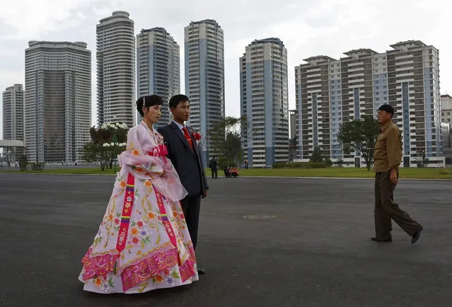 A North Korean couple pose for a wedding picture near the newly constructed development project area on Mansu Hill in Pyongyang, North Korea Wednesday, September 19, 2012. (Photo by Vincent Yu/AP Photo)
