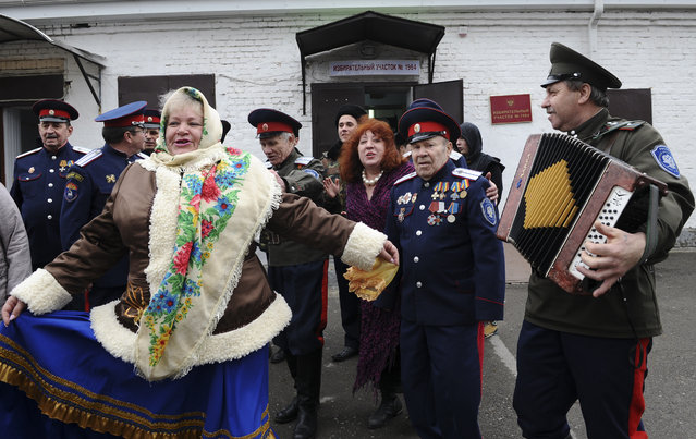 Members of a local Cossack community dance outside a polling station in Rostov-on-Don, Russia on March 18, 2018. (Photo by Sergey Pivovarov/Reuters)