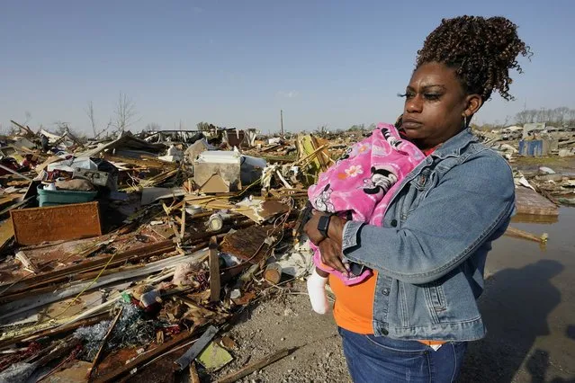Wonder Bolden cradles her year-old granddaughter Journey Bolden as she surveys the remains of her mother's tornado demolished mobile home in Rolling Fork, Miss., Saturday March 25, 2023. Emergency officials in Mississippi say several people have been killed by tornadoes that tore through the state on Friday night, destroying buildings and knocking out power as severe weather produced hail the size of golf balls moved through several southern states. (Photo by Rogelio V. Solis/AP Photo)