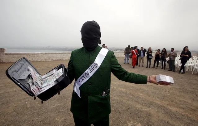 An actor portraying a "corrupted person" participates in the "Unmask the Corrupt" event, organized by the Transparency International non-governmental organization to create awareness on corruption, in Lima, November 12, 2015. (Photo by Mariana Bazo/Reuters)