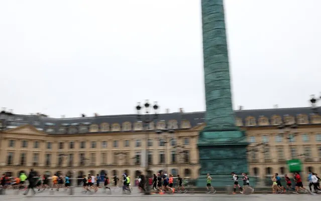 Runners compete during the 46th edition of the Paris Marathon, 42,195 km, in Paris on April 2, 2023. The 42,195 km-route kicked off on the iconic Champs Elysees heading through the Bois de Vincennes park and along the Seine river, before looping around the Bois de Boulogne and ending near the Arc de Triomphe. (Photo by Franck Fife/AFP Photo)