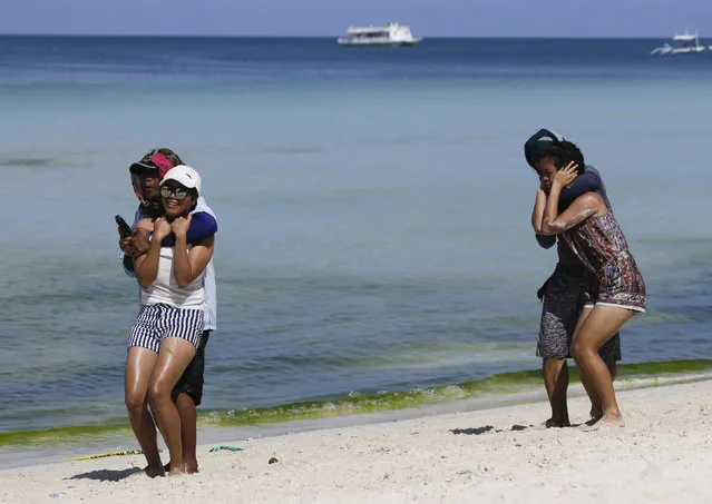 A mock hostage-taking is performed at a security drill at the country's most famous beach resort island of Boracay, in central Aklan province, Philippines Wednesday, April 25, 2018, a day before the government implements its temporary closure. Thousands of workers will be affected when Boracay will be closed after Philippine President Rodrigo Duterte orders its closure on April 26 for up to six months after saying the waters off its famed white-sand beaches had become a “cesspool” due to overcrowding and development. (Photo by Aaron Favila/AP Photo)