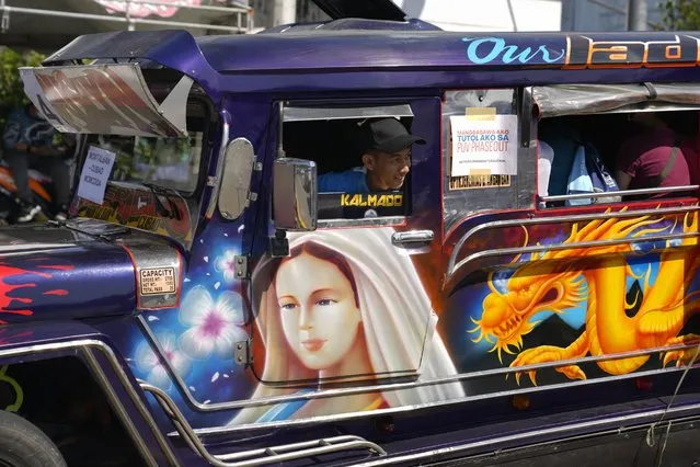 A driver looks out from his passenger jeepney as he joins a rally during a transport strike in Quezon city, Philippines on Monday, March 6, 2023. (Photo by Aaron Favila/AP Photo)
