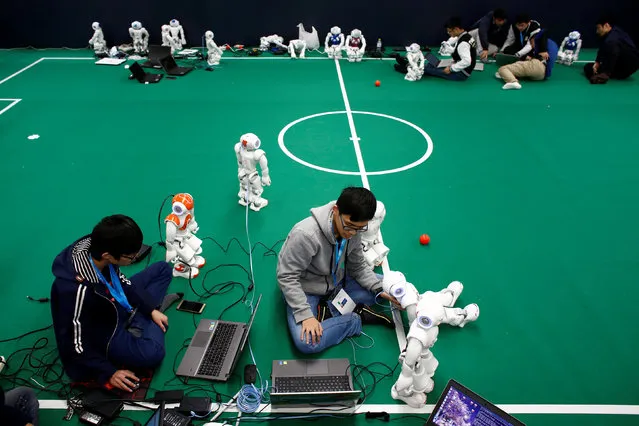 People program NAO robots to prepare them for a robot soccer competition at the WRC 2016 World Robot Conference in Beijing, China, October 21, 2016. (Photo by Thomas Peter/Reuters)