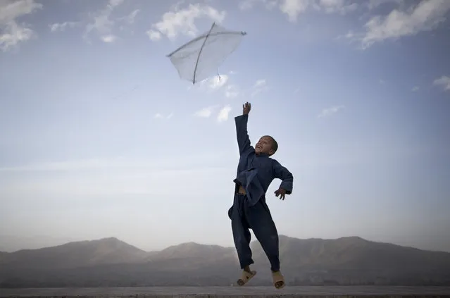 An Afghan boy flies his kite on a hill overlooking Kabul, Afghanistan, May 13, 2013. Banned during the Taliban regime, kite flying is once again the main recreational escape for Afghan boys and some men. (Photo by Anja Niedringhaus/AP Photo)