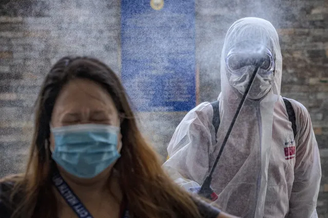 A government employee reacts as she is sprayed with disinfectant before entering a government office building to curb the spread of COVID-19 on March 19, 2020 in Pasig city, Metro Manila, Philippines. The Philippine government has sealed off Luzon, the country's largest and most populous island, to prevent the spread of COVID-19. Land, sea, and air travel has been suspended, while government work, schools, businesses, and public transportation have been ordered shut in a bid to keep some 55 million people at home. The Philippines' Department of Health has so far confirmed 217 cases of the new coronavirus in the country, with at least 17 recorded fatalities. (Photo by Ezra Acayan/Getty Images)