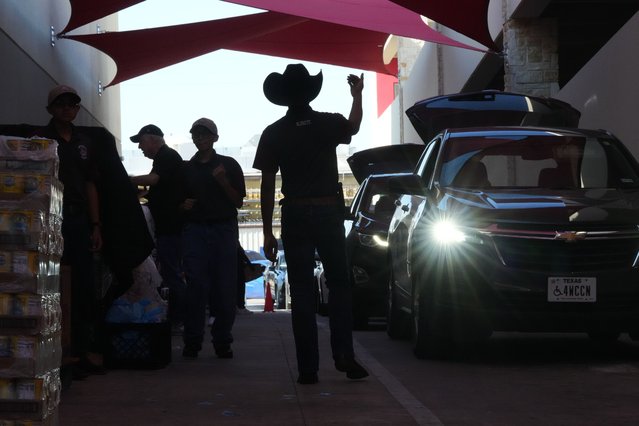 Aidan Tavor, center, directs traffic as volunteers help load vehicles during a food distribution at the San Antonio Food Bank for SNAP recipients and other households affected by the federal shutdown, Thursday, November 6, 2025, in San Antonio. (Photo by Eric Gay/AP Photo)