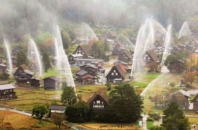 Water is sprayed during a fire drill over the World Heritage village of Shirakawa-go in Gifu Prefecture, central Japan, 26 October 2025. The annual drill is conducted to prepare for fires before the winter. (Photo by Jiji Press/EPA)