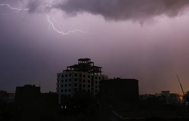 Lightning lights up moody clouds in the sky during a thunderstorm in Sana'a, Yemen, August 3, 2015. According to local reports heavy storms and torrential rain hit Sana'a and most parts of Yemen as summer temperatures sore. (Photo by Yahya Arhab/EPA)