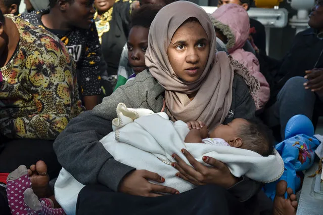 A young woman holds her baby aboard the Topaz Responder, a rescue ship run by Maltese NGO “Moas” and the Italian Red Cross, on November 4, 2016, after during a rescue operation of migrants and refugees off the Libyan coast Around 750 migrants were rescued across the Mediterranean on November 3, 2016 by the Italian coast guard, a Frontex ship, a Save The Children vessel, German NGO Jugend Rettet' s Iuventa and two boats run by the Malta- based MOAS (Migrant Offshore Aid Station). But at least 110 migrants are feared drowned after they were forced at gunpoint to set sail from Libya, while many more may have died in a separate shipwreck, survivors said. (Photo by Andreas Solaro/AFP Photo)