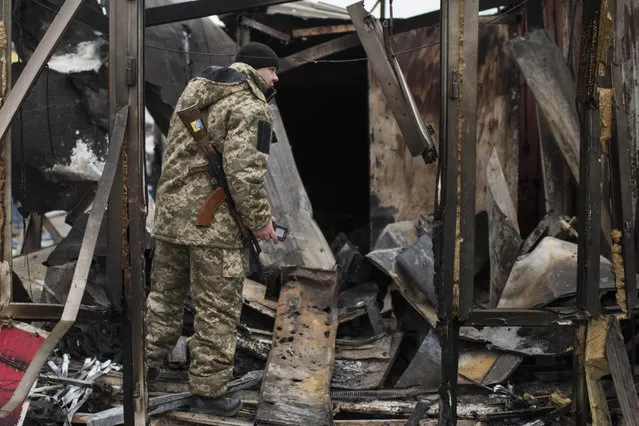 A Ukrainian serviceman stands at a market destroyed in Saturday's shelling that killed and injured scores of people in Mariupol, Ukraine, Tuesday, January 27, 2015. (Photo by Evgeniy Maloletka/AP Photo)