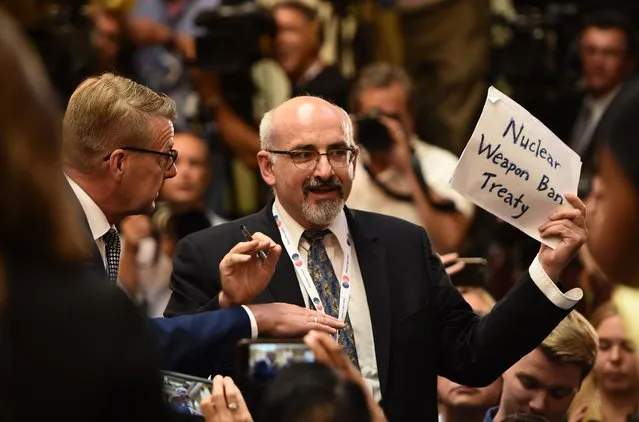 A man is escorted out of the press conference room  for having a sign reading “Nuclear weapon Ban Treaty” ahead a joint press conference of the US and Russian presidents after a meeting at the Presidential Palace in Helsinki, on July 16, 2018. (Photo by Brendan Smialowski/AFP Photo)