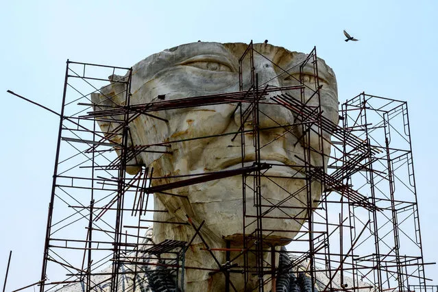 A bird flies over the abandoned giant sculpture of a Buddhist monk in Cha-am outside Hua Hin, 145km south of Bangkok, on February 25, 2021. (Photo by Mladen Antonov/AFP Photo)