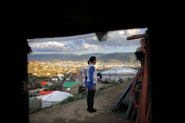 Baljirjantsan Otgonseren, 32, stands outside her family ger, a traditional Mongolian tent, in an area known as a ger district in Ulan Bator June 26, 2013. Approximately 60 percent of the population of Ulan Bator live in settlements known as ger districts and in many cases residents have limited access to basic services such as water and sanitation. According to a 2010 National Population Center census, every year between thirty and forty thousand people migrate from the countryside to the capital Ulan Bator. Ger districts in the city have been expanding rapidly in recent years. Mongolia is the world's least densely populated country, with 2.8 million people spread across an area around three times the size of France. (Photo by Carlos Barria/Reuters)