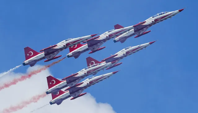 In this Saturday, July 28, 2018, NF-5 fighter jets of the Turkish Stars, Turkey's national aerobatics team, fly at the Bucharest International Air Show, or BIAS 2018, in Bucharest, Romania. Thousands of Romanians took to an airfield on the edge of the capital Bucharest for a weekend of aerobatics and air power display by more than 200 pilots and 150 aircraft from several countries.(Photo by Vadim Ghirda/AP Photo)