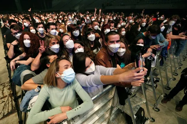 Members of the audience take a selfie as the Spanish band Love of Lesbian performs on stage in front of 5,000 people at the Palau Sant Jordi arena in Barcelona, Catalonia, Spain, 27 March 2021. This is the first crowded concert in Spain since the beginning of the COVID-19 coronavirus pandemic a year ago. People had to go through a PCR test and were given FPP2 masks before entering the test concert venue. (Photo by Alejandro Garcia/EPA/EFE)