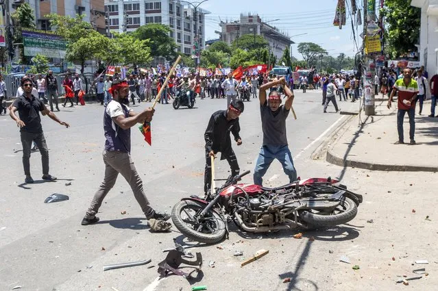 Supporters of the opposition Bangladesh Nationalist Party (BNP) vandalize a motorcycle during clashes with members of Bangladesh Chhatra League during BNP road march at the Gabtoli area in Dhaka, Bangladesh, 18 July 2023. The BNP leaders and activists are protesting to demand elections be held under a non-party interim government. (Photo by Monirul Alam/EPA)