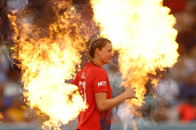 England's Lauren Bell runs out before the start of the England versus Australia cricket match as a pyrotechnic display flares in the foreground at Lord's Cricket Ground in London, England on July 8, 2023. (Photo by Matthew Childs/Action Images via Reuters)