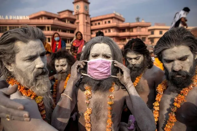 A Naga Sadhu, or Hindu holy man wears a mask before the procession for taking a dip in the Ganges river during Shahi Snan at “Kumbh Mela”, or the Pitcher Festival, amidst the spread of the coronavirus disease (COVID-19), in Haridwar, India, April 12, 2021. (Photo by Danish Siddiqui/Reuters)