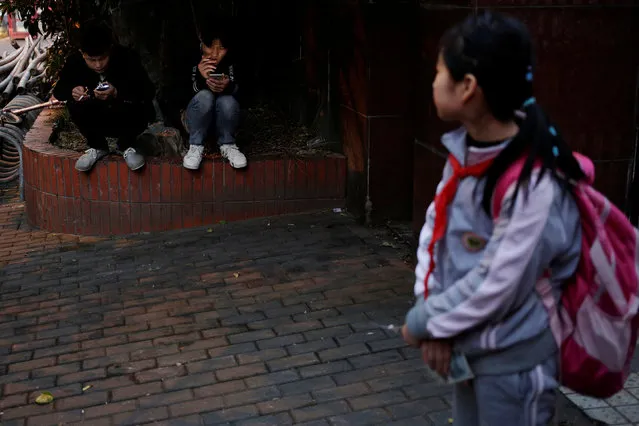 Two men check their phones on a street in Shanghai, China November 28, 2016. (Photo by Aly Song/Reuters)