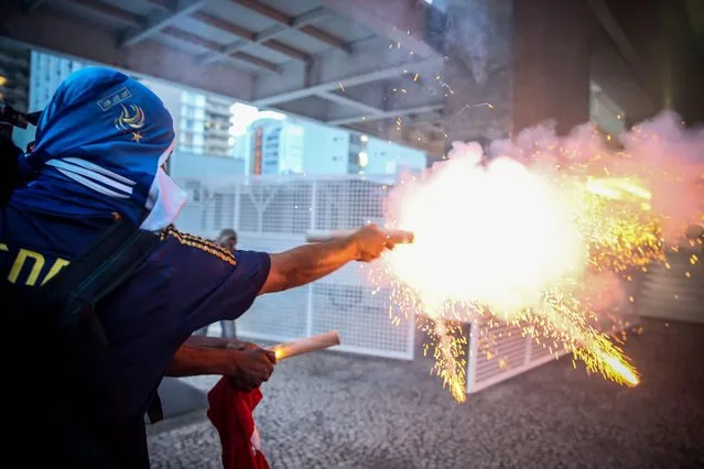 Demonstrators fire flares as they try to enter the State's Industries Federation of Sao Paulo building during protest against Brazilian President Michel Temer in Sao Paulo, in Brazil, 13 December 2016. Thousands of Brazilians protested in 13 out of the 27 states of the country against the public spending cuts proposed by the Government and passed by the Senate on 13 December as new corruption scandals were revealed. (Photo by Fernando Bizerra Jr./EPA)