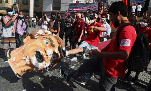 Demonstrators kick a head prop depicting Brazil's President Jair Bolsonaro during a protest in Rio de Janeiro, Brazil, May 29, 2021. Tens of thousands of protesters have poured on to the streets of Brazil’s largest cities to demand the impeachment of President Jair Bolsonaro over his catastrophic response to a coronavirus pandemic that has claimed nearly half a million Brazilian lives. (Photo by Pilar Olivares/Reuters)