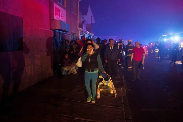 Locals evacuate their homes during a forest fire in the hills of the port city of Valparaiso, March 14, 2015. (Photo by Pablo Sanhueza/Reuters)