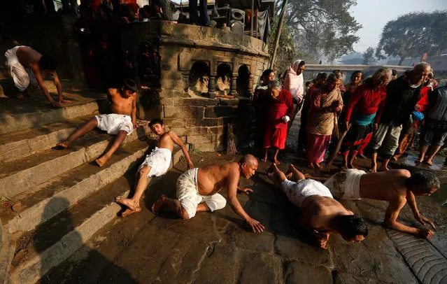 Nepalese Hindu devotees roll on the ground before taking a holy bath in the Hanumante river, during the first day of the month long Madhav Narayan fasting festival, in Bhaktapur, on the outskirts of Kathmandu, Nepal, 24 January 2016. The Madhav Narayan festival is a full month devoted to religious fasting, holy bathing and the study of the Swasthani book, a chapter or story of which is read each evening by priests or householders to the gathered family. (Photo by Narendra Shrestha/EPA)