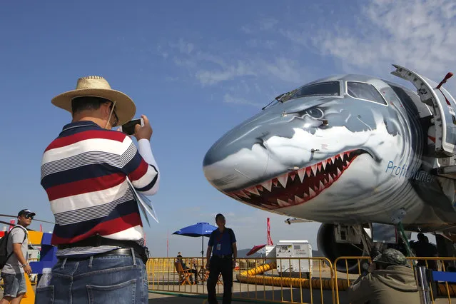 A man takes photo of the Embraer E190-E2 Commercial Jet during the 12th China International Aviation and Aerospace Exhibition, also known as Airshow China 2018, in Zhuhai city, south China's Guangdong province, Wednesday, November 7, 2018. (Photo by Kin Cheung/AP Photo)