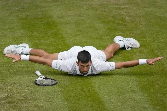 Serbia's Novak Djokovic reacts after making a passing shot to Italy's Jannik Sinner in a men's singles quarterfinal match on day nine of the Wimbledon tennis championships in London, Tuesday, July 5, 2022. (Photo by Alberto Pezzali/AP Photo)