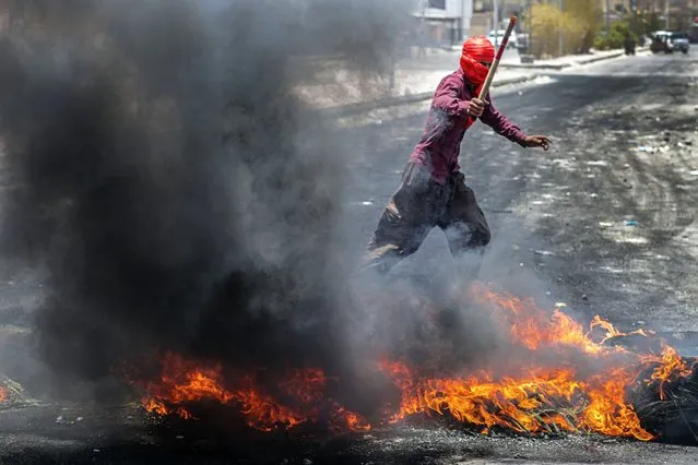 Protesters burn tires to block roads during a demonstration demanding the return of electricity in Basra, southeast of Baghdad, Iraq, Friday, July 2, 2021. A widespread power outage is hitting Iraq as temperatures reach scorching levels, affecting even affluent areas in the capital and stirring concerns of widespread unrest. (Photo by Nabil al-Jurani/AP Photo)