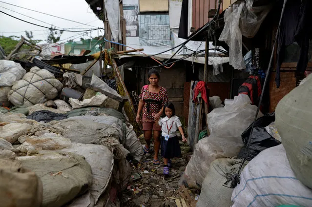 Weng Ruda, 36, mother of three walks her daughter to school at a slum area in Quezon city, Metro Manila, Philippines October 13, 2016. “I like that he is very tough. There are no children loitering around now. They also avoid picking up bad habits”, she said. (Photo by Ezra Acayan/Reuters)