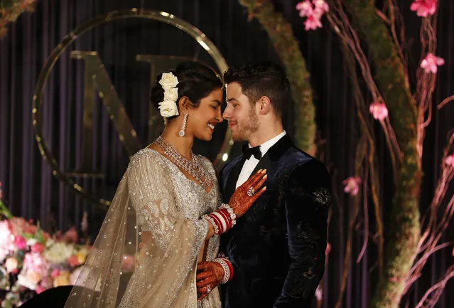 In this Tuesday, December 4, 2018, file photo, Bollywood actress Priyanka Chopra and musician Nick Jonas stand for photographs at their wedding reception in New Delhi, India. (Photo by Altaf Qadri/AP Photo)