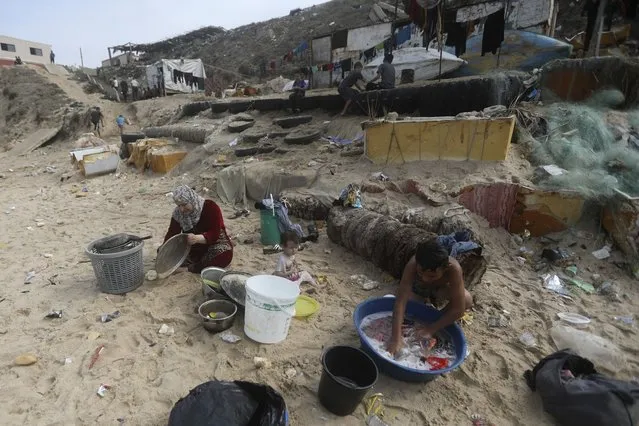 Palestinians resort to the sea water to bathe and clean their tools and clothes due the continuing water shortage in the Gaza Strip, on the beach of Deir al-Balah, Central Gaza Strip, Sunday, October 29, 2023. (Photo by Mohammed Dahman/AP Photo)