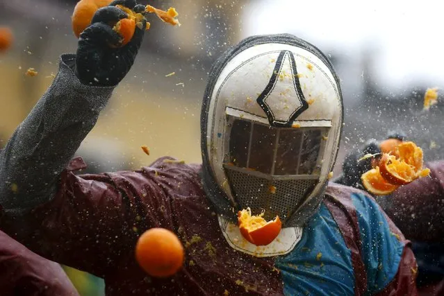 A member of a rival team is hit by an orange during an annual carnival battle in the northern Italian town of Ivrea February 7, 2016. (Photo by Stefano Rellandini/Reuters)