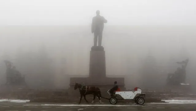 A man rides on a horse cart past a monument of Soviet State founder Vladimir Lenin on a central square during a foggy day in Stavropol, southern Russia December 29, 2016. (Photo by Eduard Korniyenko/Reuters)