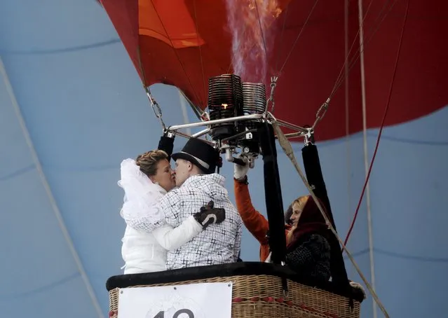Newlyweds kiss in a hot air balloon during the “Love Cup 2016” festival on Valentine's Day in Jekabpils, Latvia, February 14, 2016. (Photo by Ints Kalnins/Reuters)