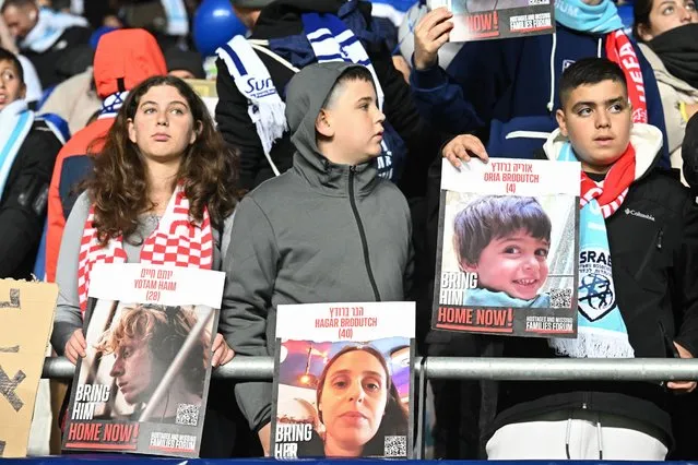 Israel fans display placards calling for the release of the hostages held by Palestinian militants since the October 7 attack, prior to the UEFA Euro 2024 Group I qualification football match Israel v Switzerland at the Pancho Arena in Felcsut, west of Budapest, Hungary on November 15, 2023. (Photo by Attila Kisbenedek/AFP Photo)