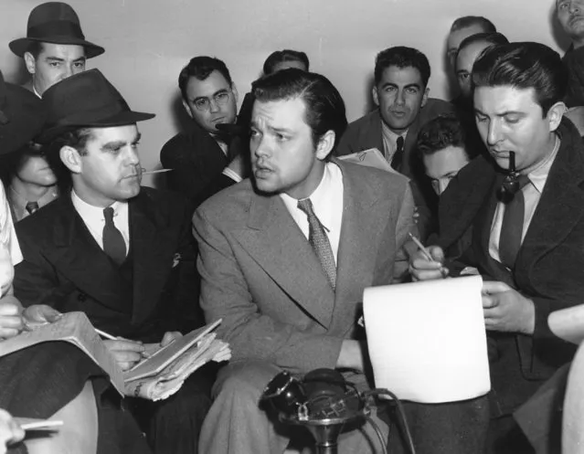 Orson Welles, center, explains to reporters on October 31, 1938 his radio dramatization of H.G. Wells' “War of the Worlds”. Meanwhile, Columbia Broadcasting System made public the transcript of the dramatization, which was aired the night of Oct. 30 and caused thousands of listeners to panic because of the realistic broadcast of an imaginative invasion of men and machines from Mars. (Photo by AP Photo)
