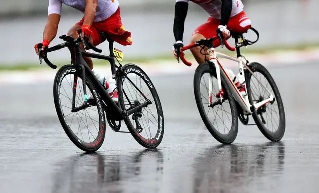 Guihua Liang of China and Shota Kawamoto of Japan compete in the men's cycling road C1-3 at the Fuji International Speedway during the Tokyo 2020 Paralympic Games in Oyama, Japan on September 2, 2021. (Photo by Lisi Niesner/Reuters)