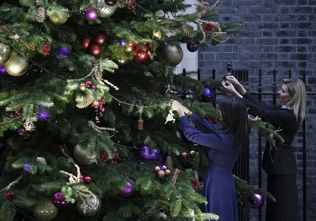 First Lady of Ukraine Olena Zelenska, right, and Rishi Sunak's wife Akshata Murty add decorations to the Christmas tree outside 10 Downing Street in London, Monday November 28, 2022, during her visit to the UK. (Photo by Yui Mok/PA Wire via AP Photo)