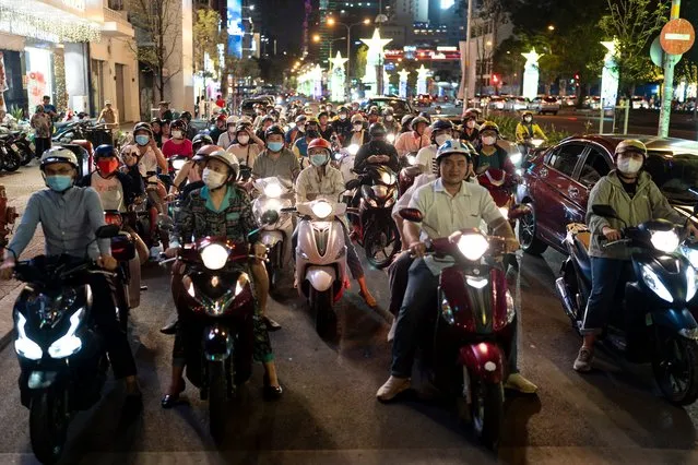Scooter commuters wait for a traffic light to change at an intersection in Ho Chi Minh City, Vietnam, Thursday, January 11, 2024. (Photo by Jae C. Hong/AP Photo)