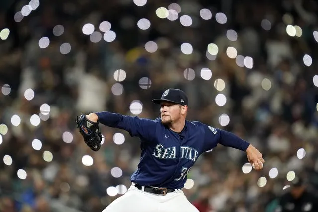 Cell phones light up the seats behind as Seattle Mariners relief pitcher Anthony Misiewicz throws against the Los Angeles Angels in the seventh inning of a baseball game Saturday, October 2, 2021, in Seattle. (Photo by Elaine Thompson/AP Photo)