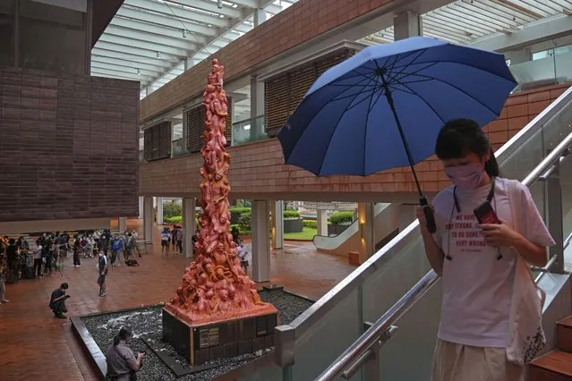 A woman walks in front of the “Pillar of Shame” statue, a memorial for those killed in the 1989 Tiananmen crackdown, at the University of Hong Kong, Wednesday, October 13, 2021. Danish artist Jens Galschioet is seeking to get back his sculpture in Hong Kong memorializing the victims of China's 1989 Tiananmen Square crackdown as a deadline loomed for its removal Wednesday. (Photo by Kin Cheung/AP Photo)